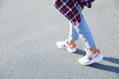 Dışarıda yürüyen bir kadın, mesaj için yer ararken yakın plan. Yol konsepti seçiliyor.