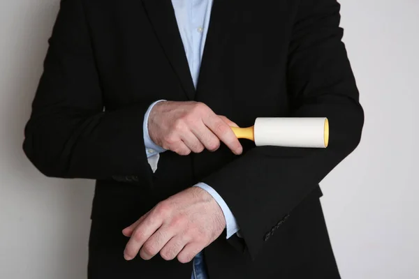 Man Cleaning Black Jacket Lint Roller Light Grey Background Closeup — Stock Photo, Image