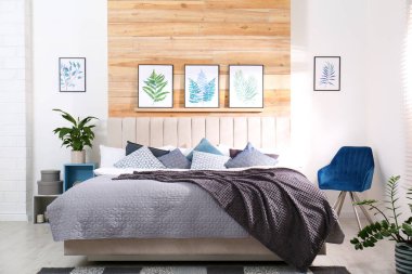 Geniş rahat yatak ve güzel tablolarla süslü bir oda.