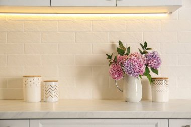 Güzel mor ortanca çiçekleri ve açık tezgahta kavanozları olan bir buket.