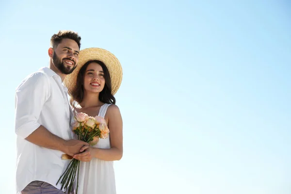 Glada Unga Par Med Blommor Mot Blå Himmel Bröllopsresa — Stockfoto
