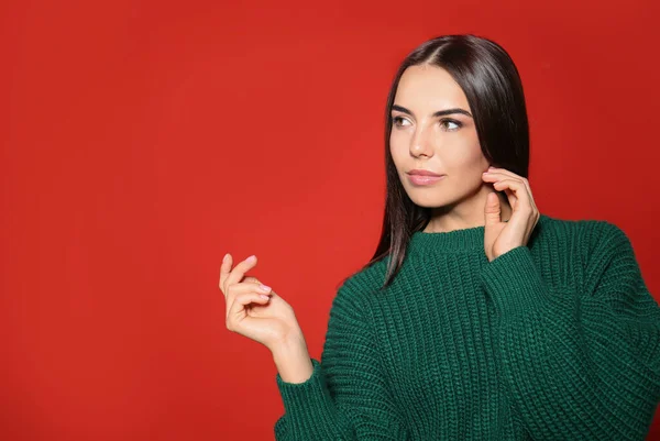Hübsche Frau Trägt Warmen Pullover Auf Rotem Hintergrund — Stockfoto