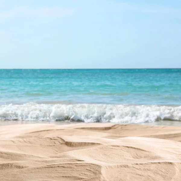 Okyanus dalgaları kumlu sahilde akıyor, yakın çekim manzarası