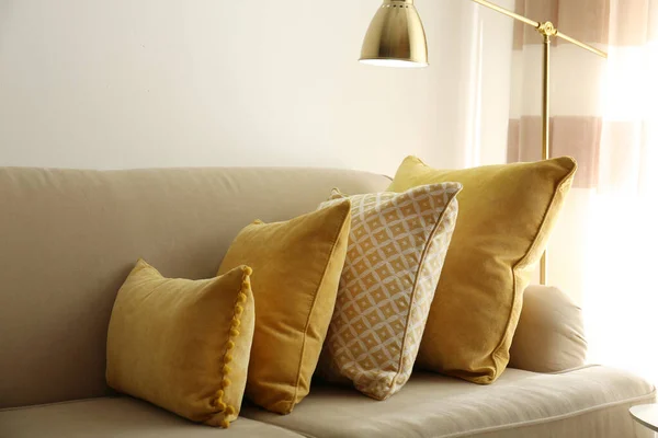 Three pillows on sofa near wall in room. Interior design