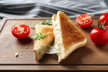 Tahtada peynirli ve domatesli lezzetli tost sandviçleri.