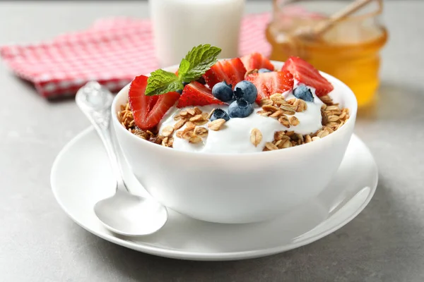 带有酸奶和浆果的味道鲜美的格拉诺拉早餐放在轻薄的桌子上 — 图库照片