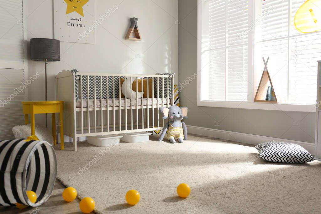 Cute baby room interior with crib and decor elements