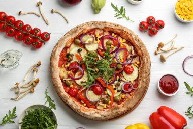 Düz kompozisyon ve sebze pizzası beyaz ahşap masada.