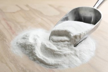 Tahta masadaki kepçedeki kabartma tozu.
