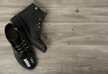 Ahşap arka planda bir çift şık ayak bileği çizmesi, üst manzara. Metin için boşluk