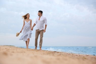 Kumsalda romantik yürüyüş yapan mutlu bir çift. Metin için boşluk