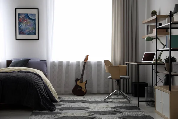 Modern gençlerin odasının içinde iş yeri ve yatak var.