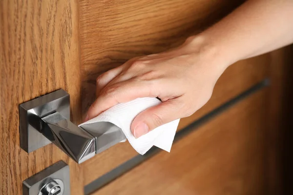 Kadın kapıyı açmak için kağıt mendil kullanıyor.