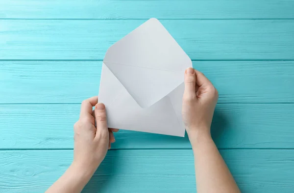 Vrouw Met Witte Papieren Envelop Aan Lichtblauwe Houten Tafel Bovenaanzicht — Stockfoto