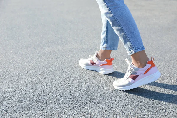 Dışarıda yürüyen bir kadın, mesaj için yer ararken yakın plan. Yol konsepti seçiliyor.