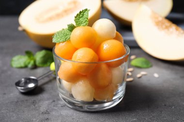 Kavun topları ve nane şekeri gri masada, yakın plan.