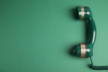 Yeşil arka planda eski model telefon, üst manzara. Metin için boşluk