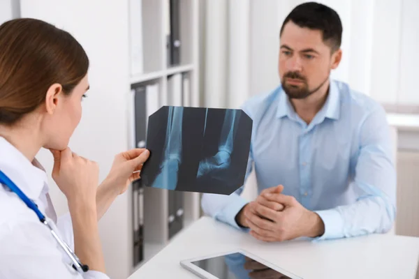 Orthopeed Toont Röntgenfoto Aan Patiënt Aan Tafel Kliniek — Stockfoto