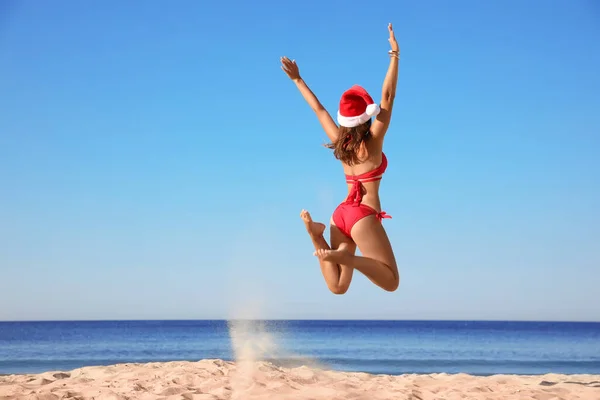 Молода Жінка Санта Капелюсі Бікіні Стрибають Пляж Простір Тексту Різдвяна — стокове фото