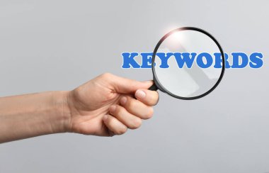 Kadın büyüteçten kelimeye bakıyor, yakın plan.