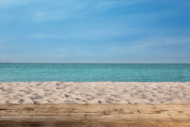 Okyanusun yakınındaki kumlu sahilde ahşap yüzey