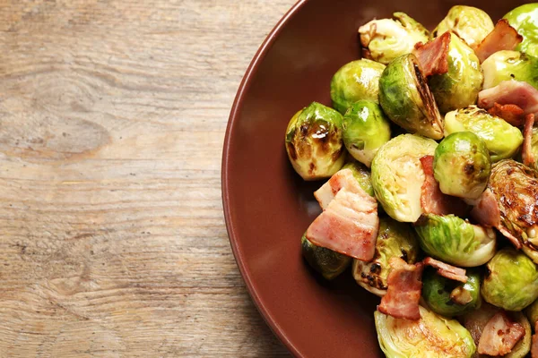 Heerlijke Gebakken Spruitjes Met Spek Houten Tafel Bovenaanzicht — Stockfoto