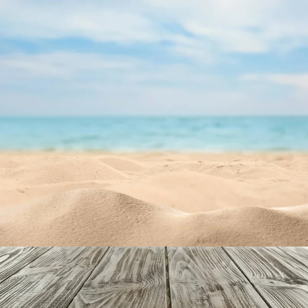 Okyanusun yakınındaki kumlu sahilde ahşap yüzey