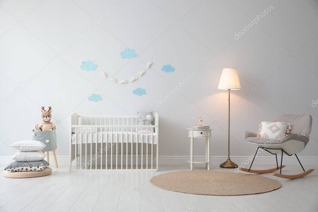 Stylish baby room interior with crib and rocking chair