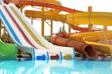 Güneşli bir günde su parkında farklı renkli slaytlar