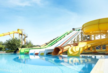 Güneşli bir günde su parkında farklı renkli slaytlar