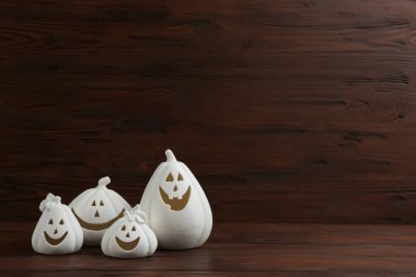 Beyaz balkabağı şekilli mum tutacakları ahşap arka planda, mesaj için yer var. Cadılar Bayramı dekorasyonu