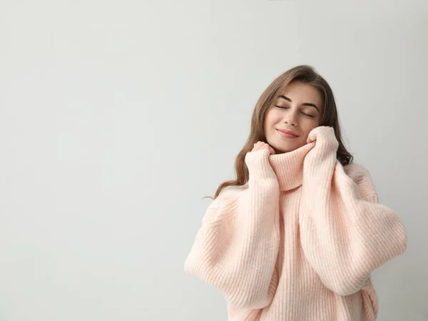 明るい背景に暖かいピンクのセーターを着た美しい若い女性 テキストのスペース — ストック写真