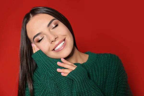 Mujer Joven Feliz Vistiendo Suéter Caliente Sobre Fondo Rojo —  Fotos de Stock