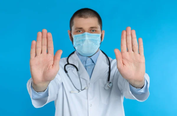 Dokter Beschermend Masker Toont Stop Gebaar Lichtblauwe Achtergrond Voorkomen Van — Stockfoto