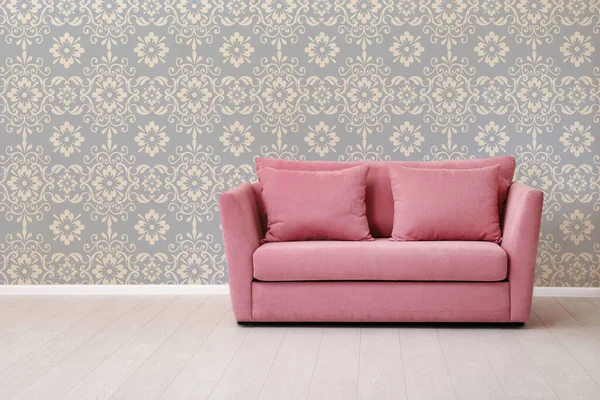 Modern sofa near patterned wallpapers. Interior design