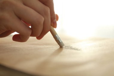 Kağıt üzerinde silgi ile resmi düzelten kadın, yakın plan