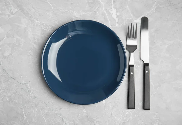 Κενό Μπλε Κεραμικό Πιάτο Και Μαχαιροπήρουνα Ανοιχτό Γκρι Μαρμάρινο Τραπέζι — Φωτογραφία Αρχείου
