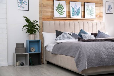 Geniş rahat yatak ve güzel tablolarla süslü bir oda.