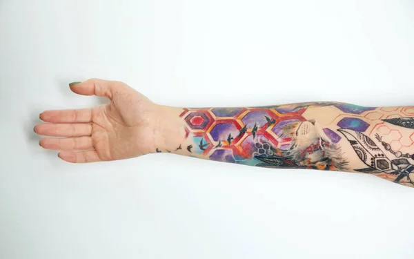 Woman with colorful tattoos on arm against white background, closeup