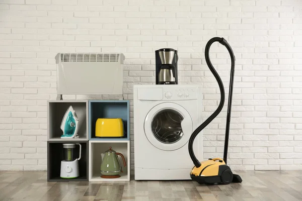 Moderne Stofzuiger Verschillende Huishoudelijke Apparaten Buurt Van Witte Bakstenen Muur — Stockfoto