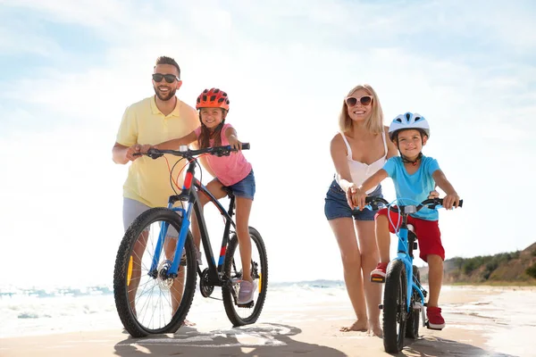 Ευτυχείς Γονείς Μαθαίνουν Στα Παιδιά Οδηγούν Ποδήλατα Αμμώδη Παραλία Κοντά — Φωτογραφία Αρχείου