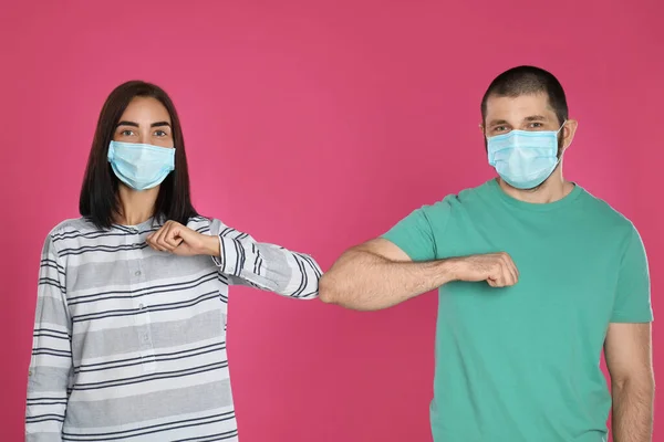 남자와 여자는 분홍색 배경에서 인사를 팔꿈치를 부딪치고 코로나 바이러스 유행병이 — 스톡 사진