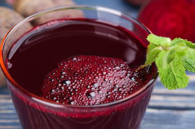 Mavi masadaki bardakta taze pancar suyu, yakın plan.