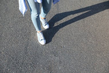 Dışarıda yürüyen bir kadın, mesaj için yer ararken yakın plan. Yol konsepti seçiliyor.