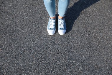 Dışarıda duran bir kadın, mesaj için yere yakın duruyor. Yol konsepti seçiliyor.