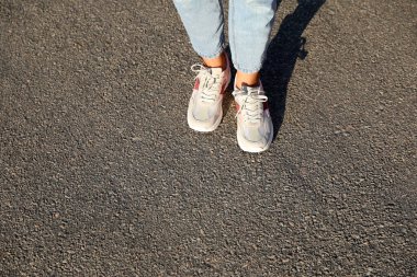 Dışarıda duran bir kadın, mesaj için yere yakın duruyor. Yol konsepti seçiliyor.