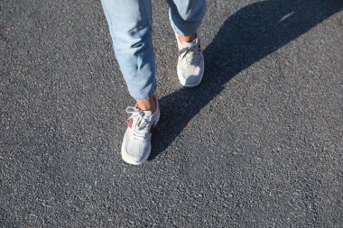 Dışarıda yürüyen bir kadın, mesaj için yer ararken yakın plan. Yol konsepti seçiliyor.