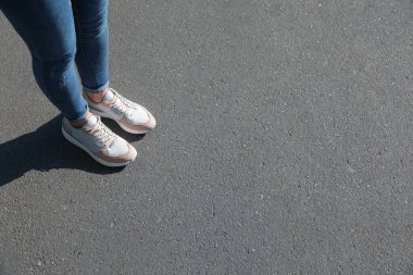 Dışarıda duran bir kadın, mesaj için yere yakın duruyor. Yol konsepti seçiliyor.