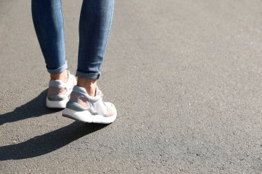 Dışarıda yürüyen bir kadın, mesaj için yer ararken yakın plan. Yol konsepti seçiliyor.