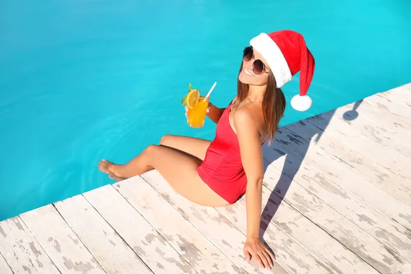 Mujer Joven Sombrero Santa Claus Con Refrescante Bebida Cerca Piscina —  Fotos de Stock